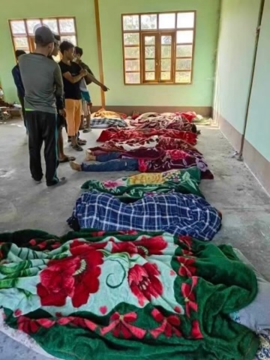 人們在卡南村的一棟建築物內指認罹難者。（圖／AMG International）